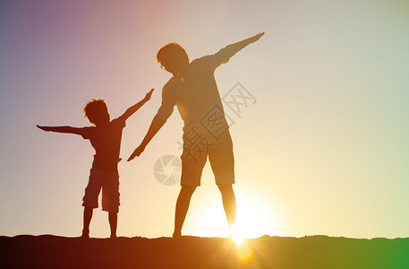 父亲和儿子在日落的天图片