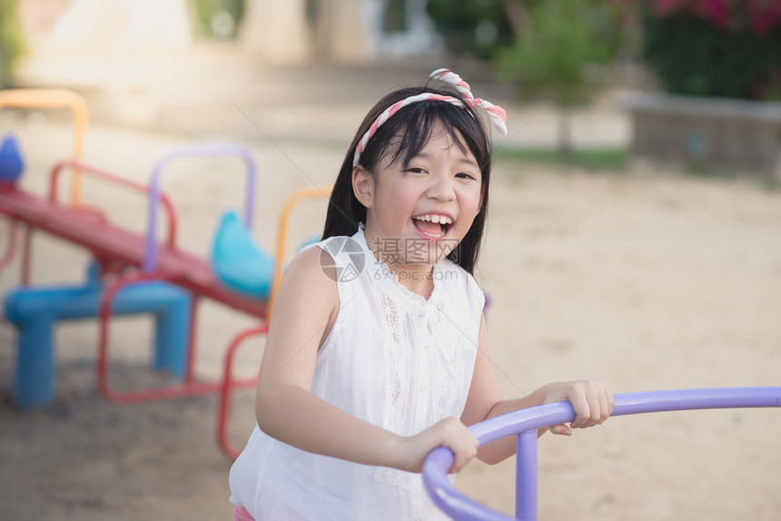 小亚洲小孩在户外的旋转木图片