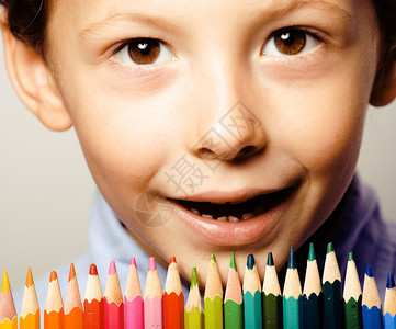 可爱的小男孩有彩色铅笔紧贴着微图片