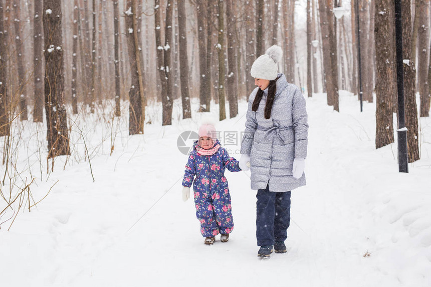 家庭冬天和自然概念年轻快乐的母亲与可爱的小女儿在图片