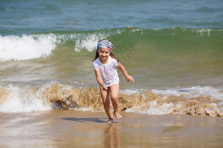 孩子在海浪背景的沙滩上奔波浅的田地深度图片