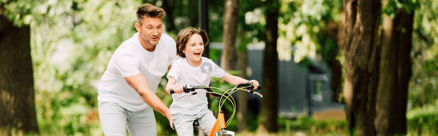 儿子骑自行车时父亲推自行图片