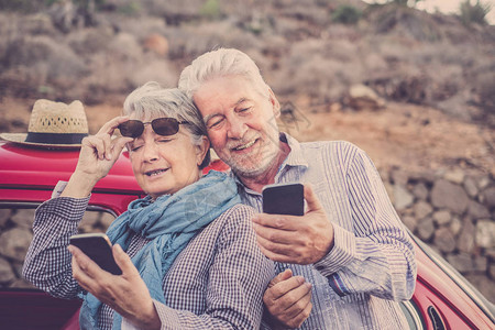 快乐的老年夫妇在户外使用手机图片