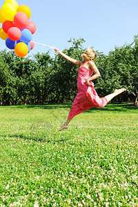 女孩跳着气球试图飞图片