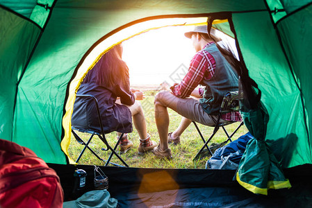 男女露营者在露营帐篷前交谈人和生活方式的概念野餐和旅行的概念夏季主题的自然后视图背景图片