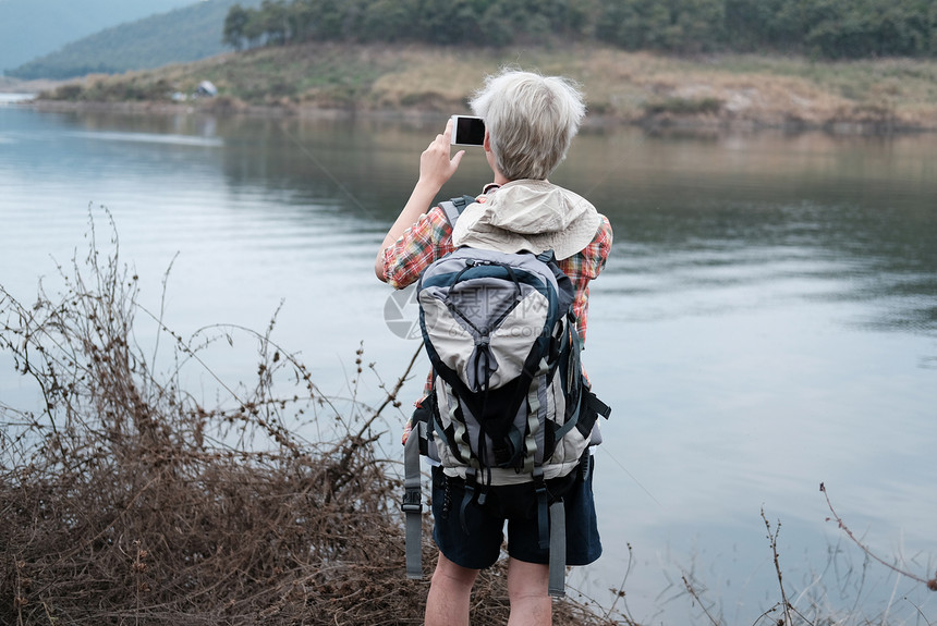 旅游背包人使用智能电话照相旅行生活方式和暑假概念ACN9WGIIIWP图片