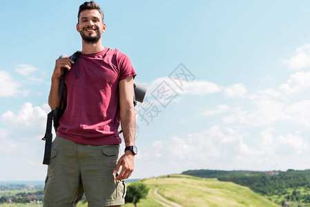 微笑的年轻徒步旅行者背包站图片