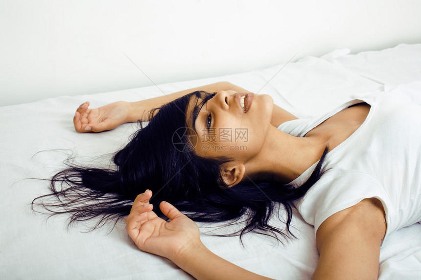 漂亮的黑白混血黑发女人躺在床上图片