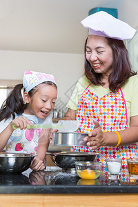 亚洲妈教女儿在家中现实生活的厨房图片