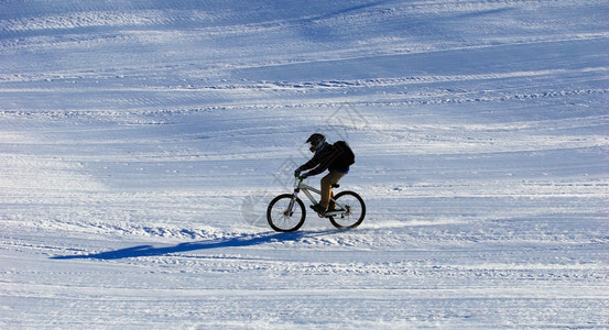 滑雪胜地斜坡上的山地自行车手下坡图片