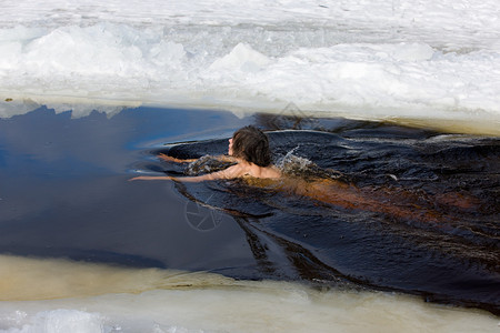 女人在湖上的冰洞里游泳图片