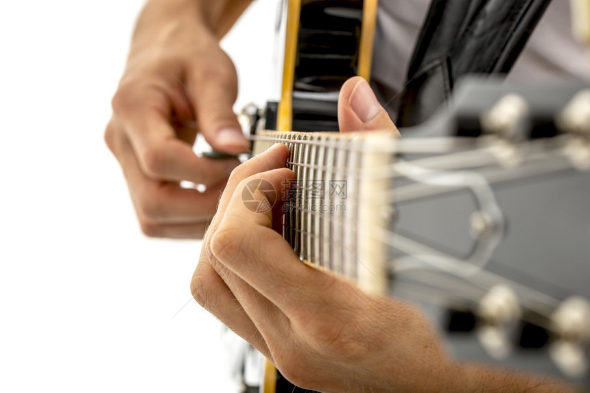 近距离的斜角视图一个男人的手指弹吉他选择字符串上的音符图片