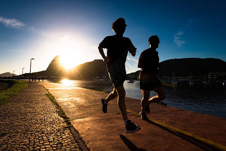 清晨在里约热内卢美丽的暖日升起和地平线上的甘露叶山的美丽温暖中奔跑时图片