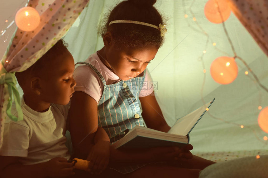 在小屋里读睡前故事的非洲裔美国小孩子图片