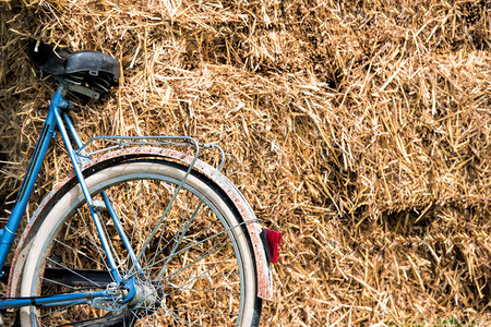 一堆干草附近的复古蓝色自行车部分视图背景图片