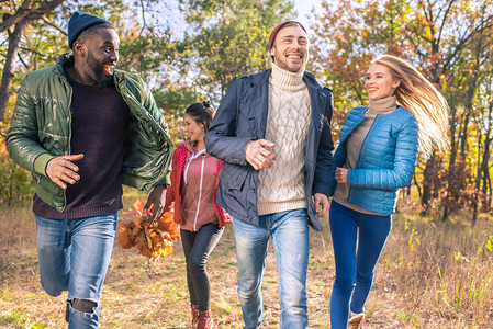 一群快乐的年轻朋友在秋天公园散步图片