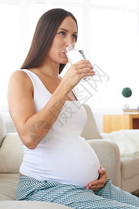 正面孕妇的侧面观点从玻璃图片