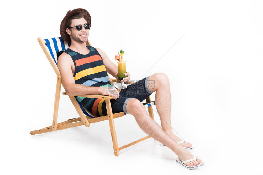 穿着太阳眼镜的帅男戴着墨镜和讨厌在沙椅上放松图片