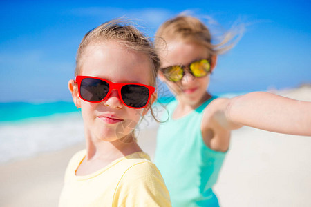 小女孩用摄影机拍摄热带海滩的视频或照片图片
