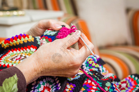 高龄女人的手织着长年羊毛涂图片