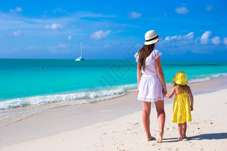 年轻母亲在海滩上与女儿图片