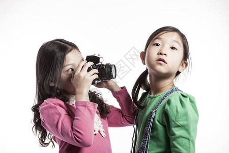 两个亚裔女孩边拍照边玩背景图片