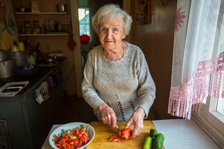 老妇人在村屋里准备饭菜图片