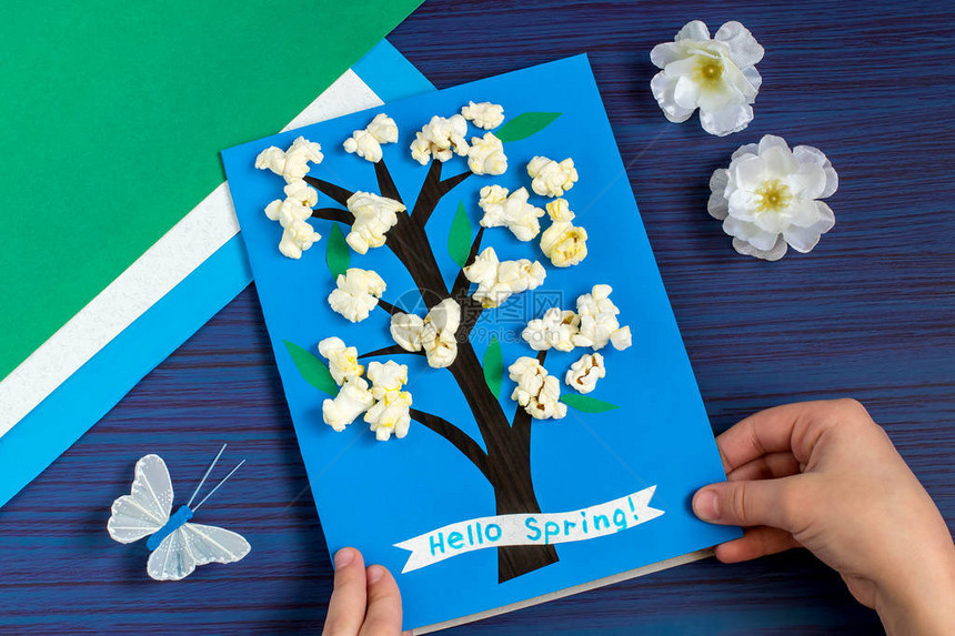 一个孩子在春季主题上制作卡片蓝色背景上开花的树原创儿童艺术项目DIY概念一步的照片说明步骤8图片