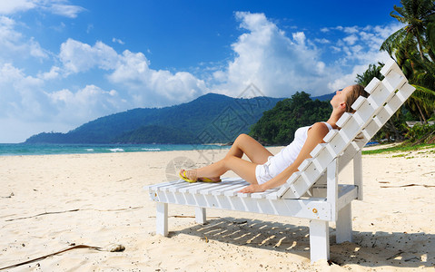 在热带海滩上的女孩坐图片