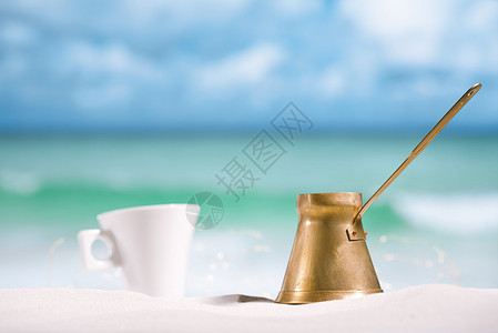 茶壶和杯子在海滩上有海图片