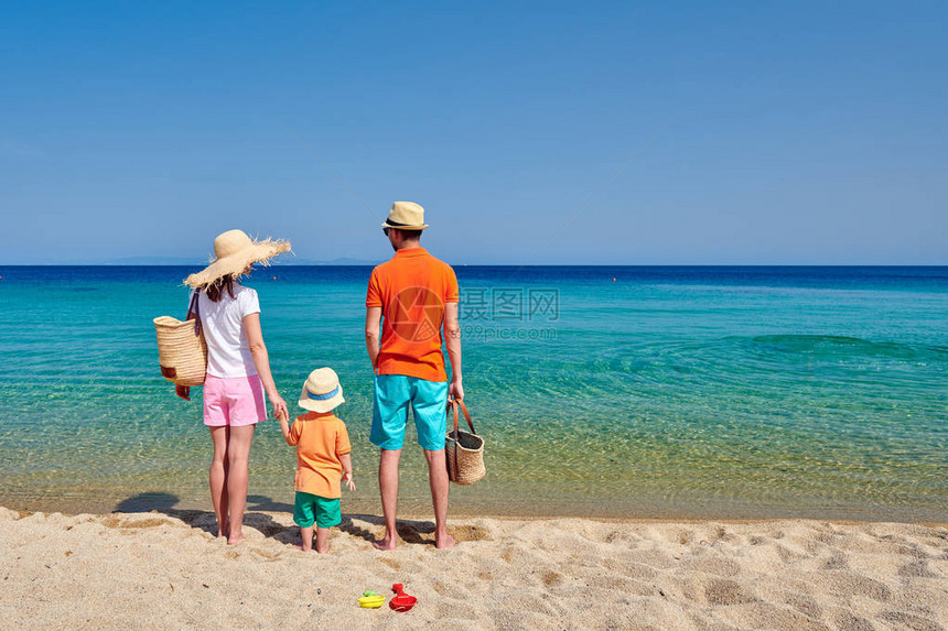 家庭在海滩上年轻夫妇与三岁男孩在一起图片