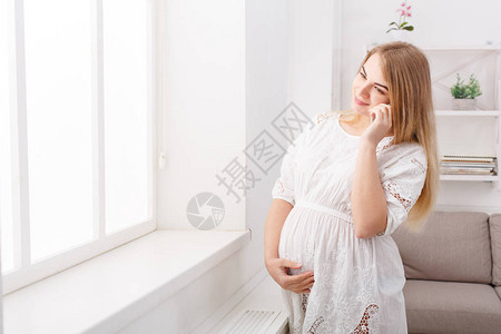 微笑的期待金发女郎在电话里愉快地交谈图片