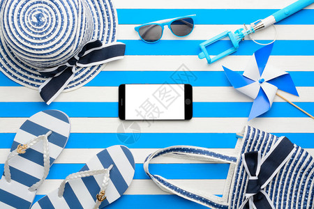 白色和蓝色背景的沙滩附件和智能手机图片