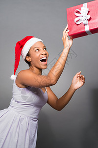 一位穿着圣诞老人帽子的兴奋女士的垂直图像图片