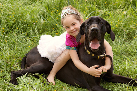 美丽的小女孩和她的拉布多宠物狗拥抱和拥抱图片