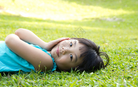 亚洲儿童躺在花园草地上的肖像图片