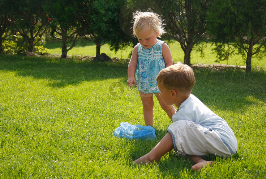 两个孩子在绿草地上玩耍图片