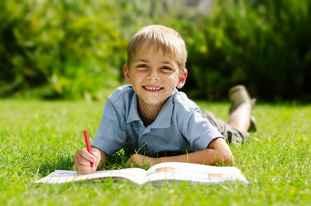 一个男孩的肖像躺在草地上的男孩和一图片