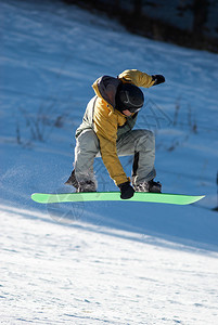在绿板上飞行滑雪板图片