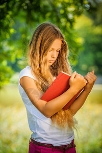 相当严厉的年轻女孩读红色书对抗图片