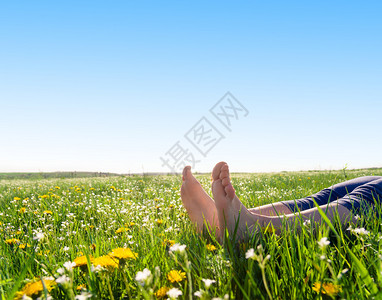 光着脚踩在春天的草地和花朵上图片