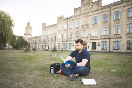 一个学生坐在草地上图片