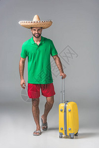 带着灰色手提箱站在墨西哥的墨西哥苏布雷罗人图片