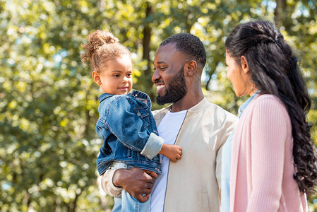 欢乐的非裔美国父母和女儿在公园里站图片