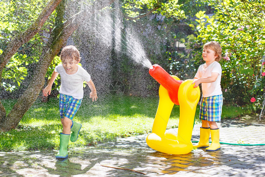 用花园软管泼水孩子们在户外玩得开心有趣的户外图片