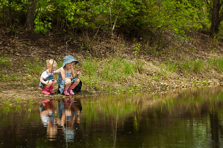 小女孩在森林里的湖上钓鱼图片