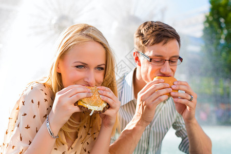 夫妻饿着肚子吃饭汉堡在午餐时图片