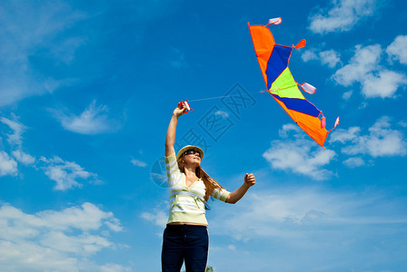 蓝天下放风筝的女人图片