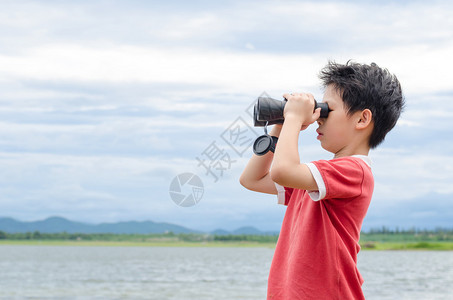 穿红色T恤衫的亚洲青年男孩使用环湖附近图片