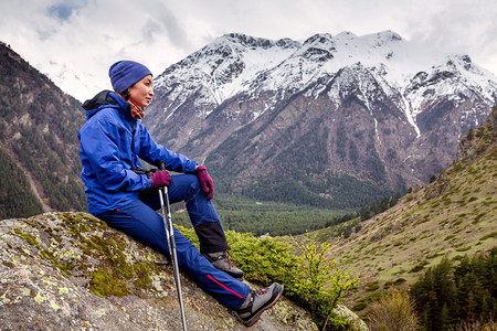 妇女徒步旅行者在高加索山顶的岩石图片